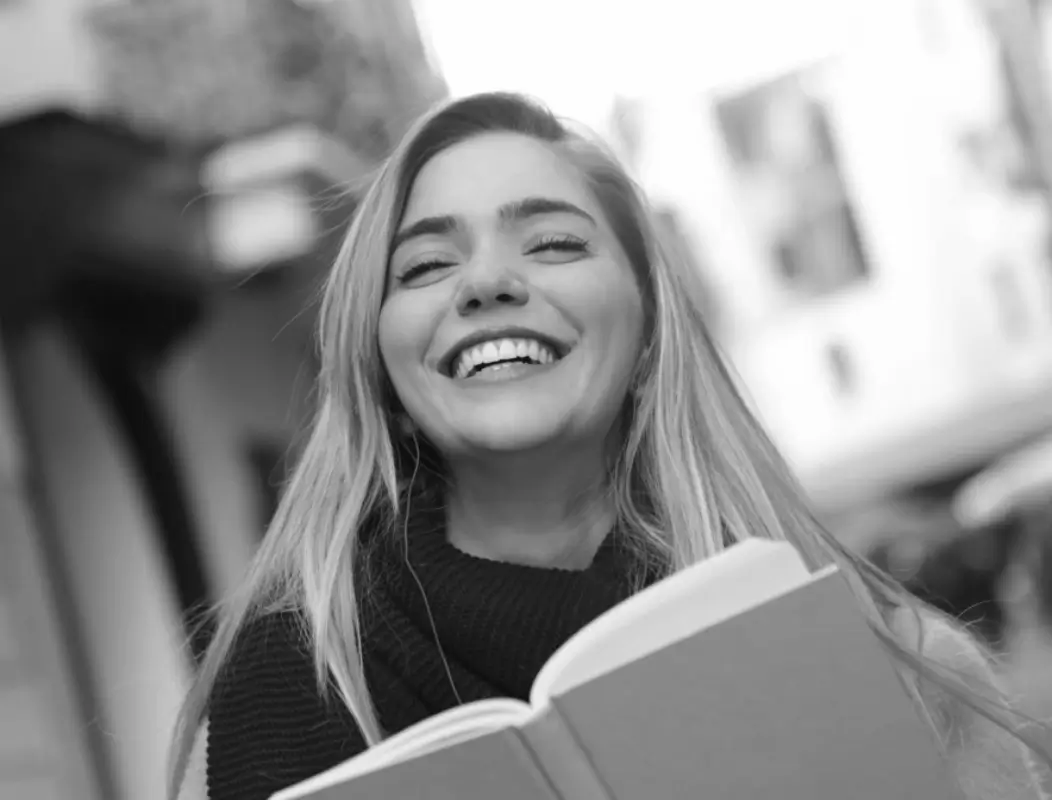 vor dem Effekt eines Schwarz-Weiß-Farbbildes einer lächelnden Dame, die ein Buch hält